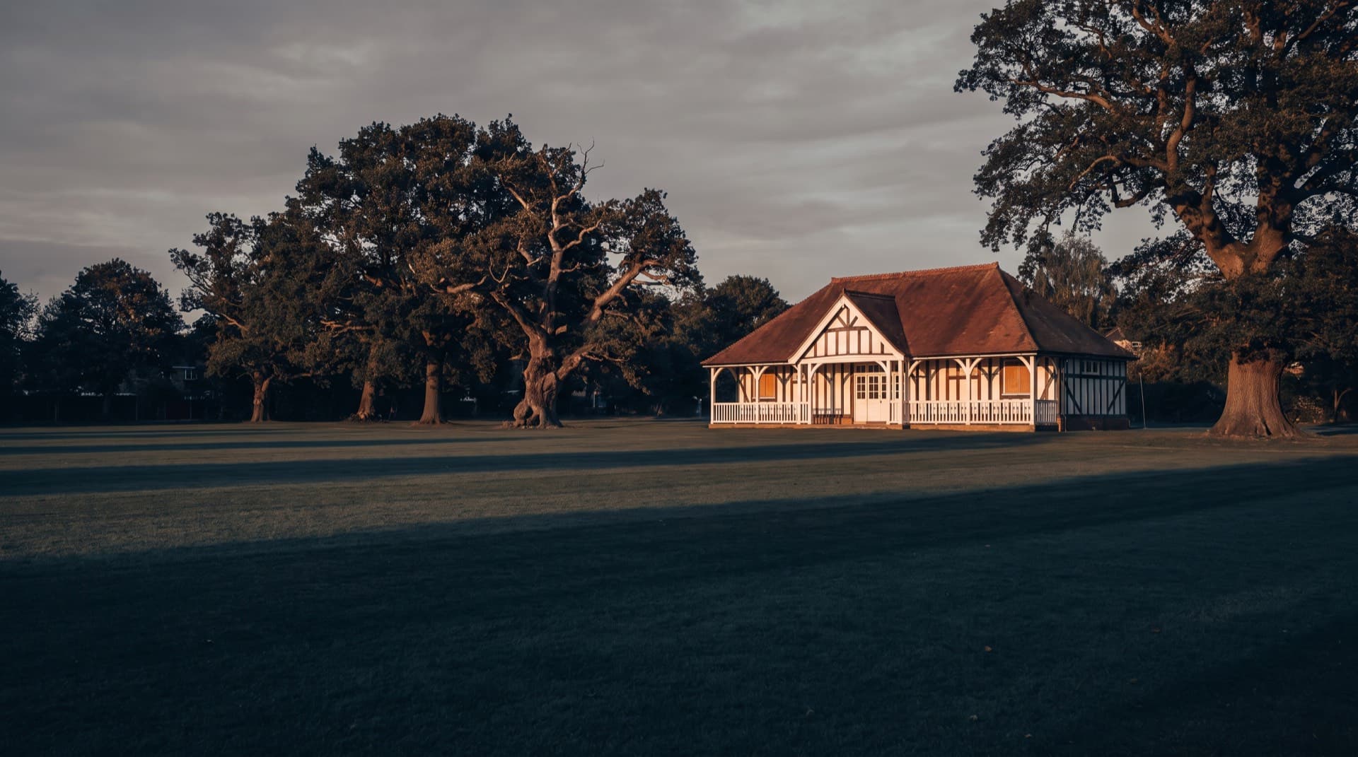 The cricket pavilion across Mitcham Cricket Green on a summer evening